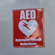 Load image into Gallery viewer, AED sticker on a wall with a red background and white text.