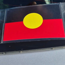 Load image into Gallery viewer, Flag with a yellow circle on a red background, placed on a reflective surface.