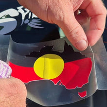 Load image into Gallery viewer, Hand holding a clear plastic sheet with an Aboriginal flag design.