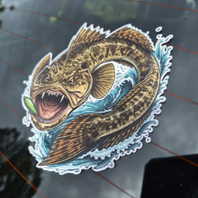 Load image into Gallery viewer, A die-cut vinyl sticker of a detailed flatty flathead fish jumping through blue water with a green lure in its mouth, shown applied to a dark tinted car window.