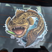 Load image into Gallery viewer, A die-cut vinyl sticker of a fierce, mouth-open flathead fish holding a green lure, applied to a dark car window.