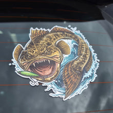 Load image into Gallery viewer, A die-cut vinyl sticker of a detailed fishing flatty fish holding a green lure, shown applied to the rear window of a vehicle.