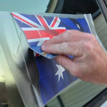 Load image into Gallery viewer, Hand applying an Australian flag decal to a car window.