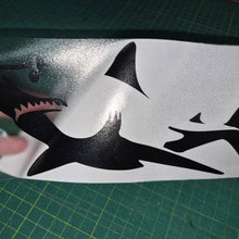 Load image into Gallery viewer, Black shark decal on a white sheet with a hand touching it, on a green cutting mat.