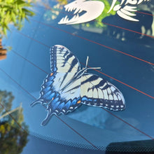 Load image into Gallery viewer, Butterfly decal on a car window with trees in the background