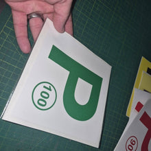 Load image into Gallery viewer, Hand holding a green 'P' with number 100 on a white background, on a green cutting mat.