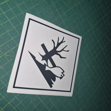Load image into Gallery viewer, Black and white sticker with tree and bird design on a green cutting mat