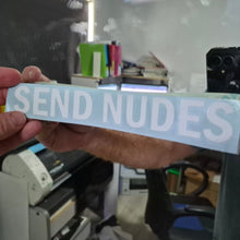 Load image into Gallery viewer, Hand holding a sticker with 'SEND NUDES' text in an indoor setting.