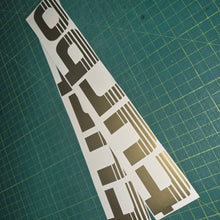 Load image into Gallery viewer, Turbo decal on a green cutting mat with grid lines