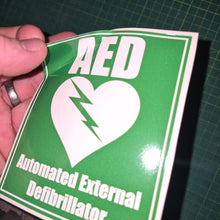 Load image into Gallery viewer, Green sticker with white text and logo on a cutting mat background
