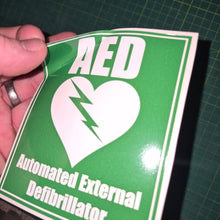 Load image into Gallery viewer, Green sticker with white text and logo on a cutting mat background