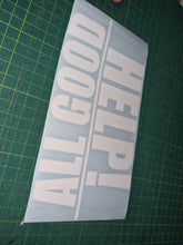 Load image into Gallery viewer, White decal with 'HELP! ALL GOOD' text on a green cutting mat