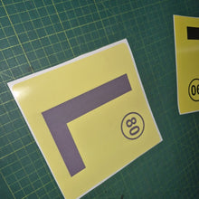 Load image into Gallery viewer, Yellow square with a purple 'L' and black number '80' on a green grid background