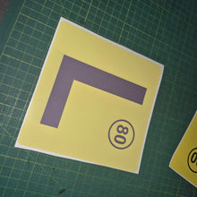 Load image into Gallery viewer, Yellow square with a purple 'L' and black number '80' on a green grid background