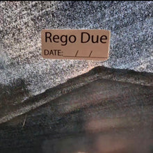 Load image into Gallery viewer, Label with 'Rego Due' text on a textured fabric background
