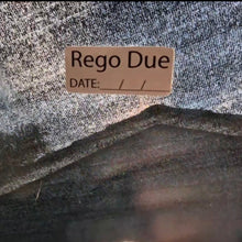 Load image into Gallery viewer, Label with 'Rego Due' text on a textured fabric background