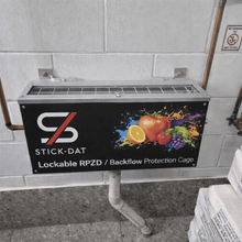 Load image into Gallery viewer, Lockable RPZD/backflow protection cage with Stick-Dat branding on a tiled wall.