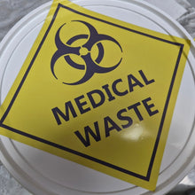 Load image into Gallery viewer, Yellow 'Medical Waste' sign decals with biohazard symbol on a white container lid.