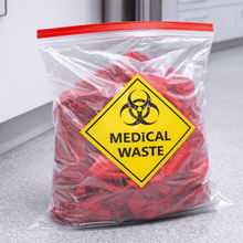 Load image into Gallery viewer, Bag labeled 'Medical Waste' with biohazard symbol on a countertop.