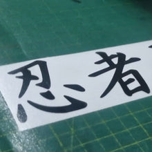 Load image into Gallery viewer, Ninja Black text on a white strip with green cutting mat background