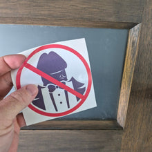 Load image into Gallery viewer, Hand holding a No Dickheads Allowed sticker against a wooden background