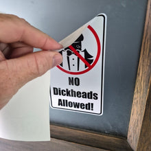 Load image into Gallery viewer, Hand holding a sticker with 'No Dickheads Allowed!' text against a mirror.