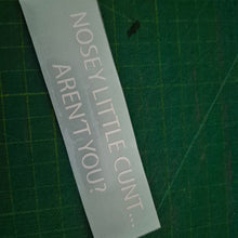 Load image into Gallery viewer, Rectangular decal with offensive text on a green cutting mat