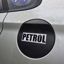 Load image into Gallery viewer, A close-up of a black oval fuel door sticker with the word 'PETROL' in bold white letters on a silver car body.