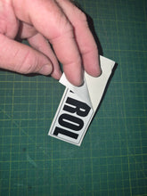 Load image into Gallery viewer, Hand holding a sticker with 'PETROL' decal on a green cutting mat.