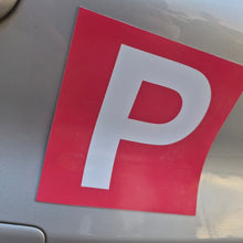 Load image into Gallery viewer, Red and white 'P' plate on a car, indicating a learner driver.