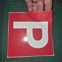 Load image into Gallery viewer, Red square sign with a white 'P' held by a hand on a green cutting mat.