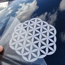 Load image into Gallery viewer, White geometric design sticker on a clear plastic application sheet held over a car window.
