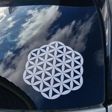 Load image into Gallery viewer, White flower of life symbol on a car window with a blue sky reflection.