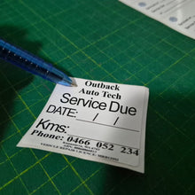 Load image into Gallery viewer, Service due label held by a hand with a pen on a green cutting mat