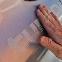 Load image into Gallery viewer, Hand touching a Silver tubro decals on white surface.