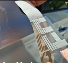 Load image into Gallery viewer, Person applying a car wrap film with a logo on a vehicle Silver tubro decals