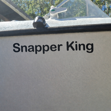 Load image into Gallery viewer, Decal on a Boat's side with 'Snapper King' text, outdoors.