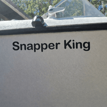Load image into Gallery viewer, Decal on a Boat's side with 'Snapper King' text, outdoors.