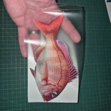 Load image into Gallery viewer, Hand holding a card with a red fish illustration on a green cutting mat.