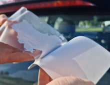 Load image into Gallery viewer, Sticker of Australia's flag and map Person holding a white plastic tool with a car in the background