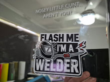 Load image into Gallery viewer, Sticker with text 'Flash me I'm a welder' held up to a mirror with text on it.