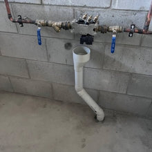 Load image into Gallery viewer, Plumbing system with pipes and valves mounted on a concrete wall.