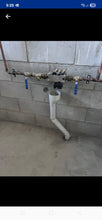 Load image into Gallery viewer, Plumbing system with pipes and valves mounted on a concrete wall.