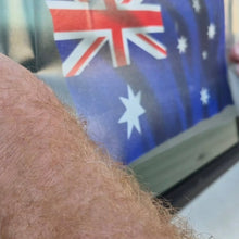 Load image into Gallery viewer, Close-up of a person applying an Australian flag in the background on a car window
