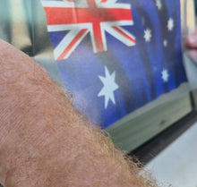 Load image into Gallery viewer, Close-up of a person applying an Australian flag in the background on a car window