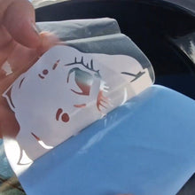 Load image into Gallery viewer, Hand holding a small plastic bag with a cartoon face design against a blurred outdoor background.