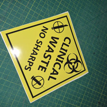 Load image into Gallery viewer, "Yellow clinical waste no sharps " warning sign decal with black text and symbols on a green grid background