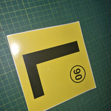 Load image into Gallery viewer, Yellow square with a black 'L' and number 90 on a green grid background