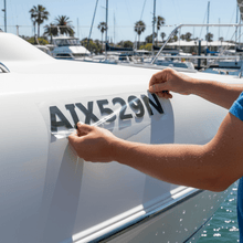 Load image into Gallery viewer, Applying rego sticker to boat hull with squeegee