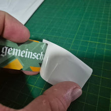 Load image into Gallery viewer, Hand holding doubled sided Service due sticker branding on a green cutting mat.